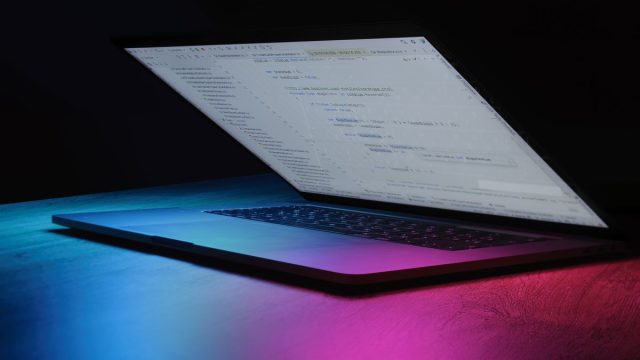 Open laptop illuminated with neon lights, available to buy on deposit