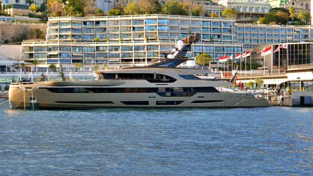 Luxury superyacht docked at Monaco harbor, available to charter with a deposit